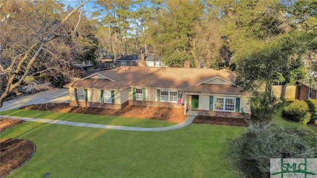 single story home featuring a front lawn, a chimney, and brick siding