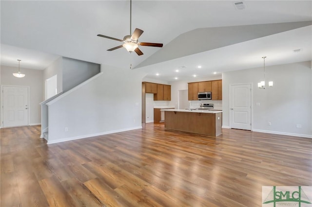 923 Highland Cir, Richmond Hill, GA 31324 - unfurnished living room featuring lofted ceiling, ceiling fan with notable chandelier, wood finished floors, visible vents, and baseboards