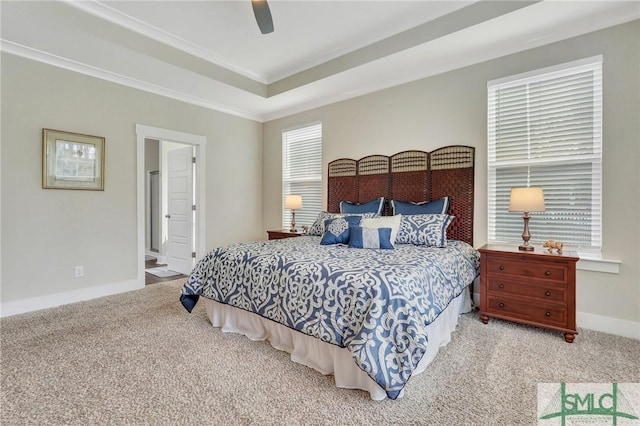 bedroom featuring baseboards, a ceiling fan, ornamental molding, a tray ceiling, and carpet floors