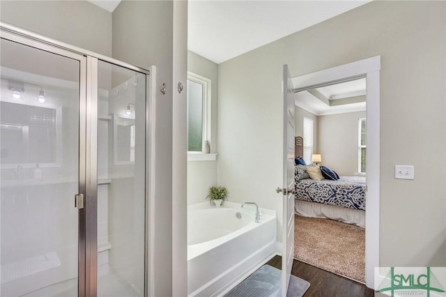 bathroom featuring a tray ceiling, connected bathroom, a shower stall, wood finished floors, and a bath