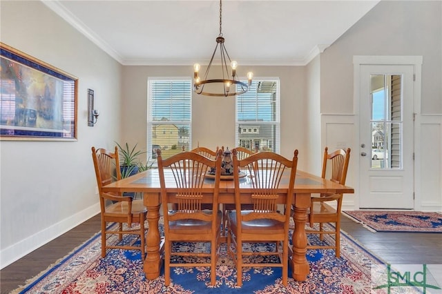 dining space with baseboards, an inviting chandelier, wood finished floors, and crown molding