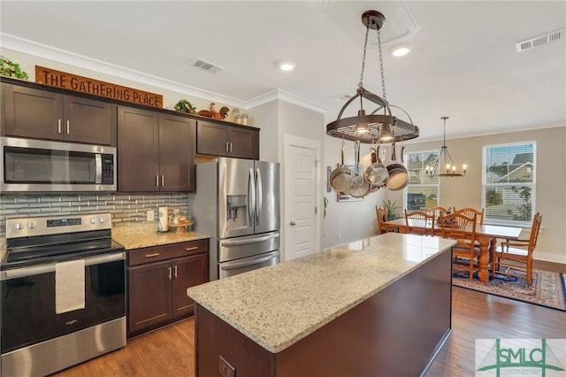 kitchen featuring light stone counters, dark wood-style flooring, visible vents, decorative backsplash, and appliances with stainless steel finishes