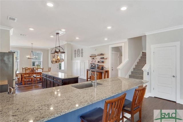 kitchen featuring crown molding, dark wood finished floors, visible vents, freestanding refrigerator, and a sink