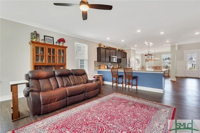 living area with a ceiling fan, dark wood finished floors, crown molding, and recessed lighting