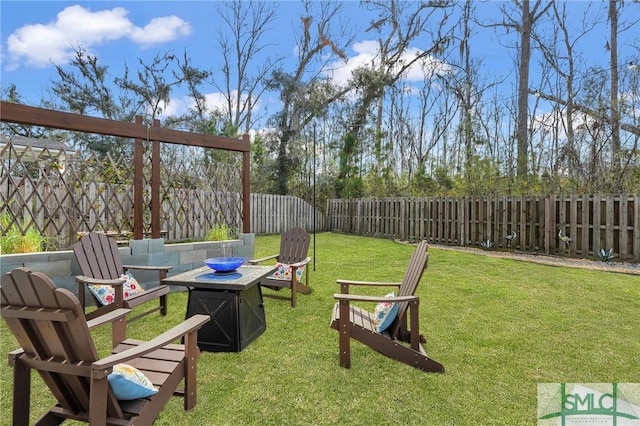 view of yard with a fenced backyard and a fire pit