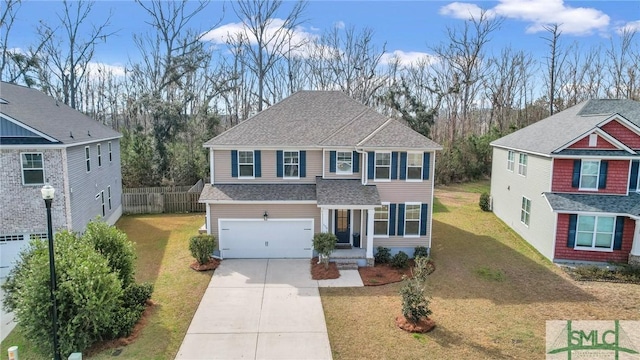 view of front of house with a garage, driveway, a shingled roof, fence, and a front lawn