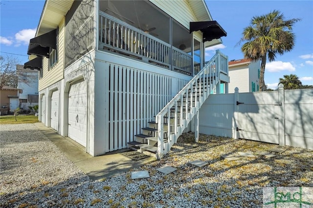 view of side of property with stairs, fence, and a garage