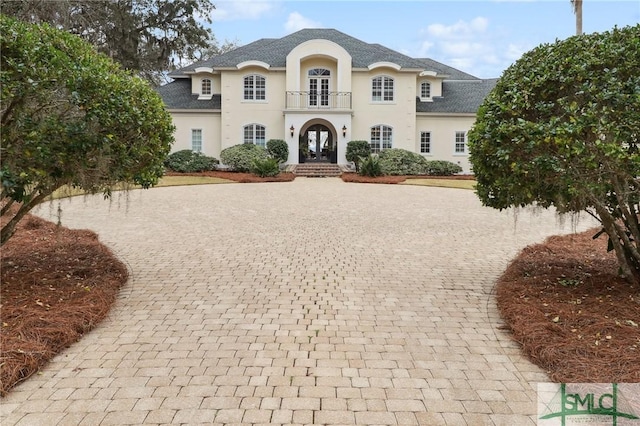 french country inspired facade featuring french doors and stucco siding