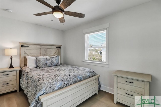 bedroom with a ceiling fan, baseboards, and wood finished floors