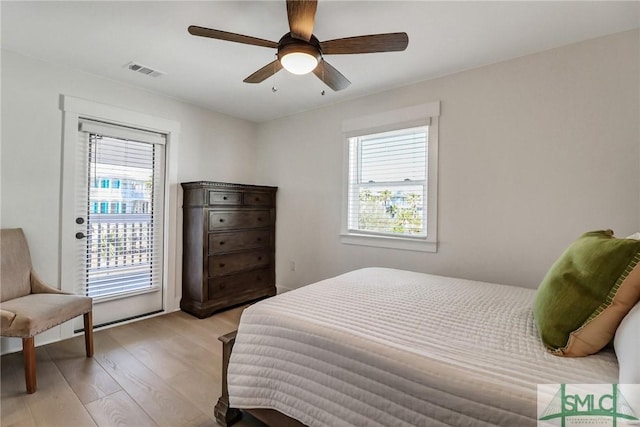 bedroom featuring light wood-style flooring, multiple windows, visible vents, and a ceiling fan