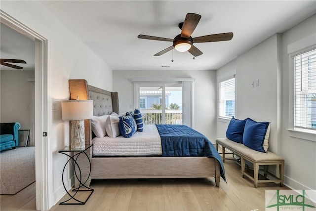 bedroom with ceiling fan, multiple windows, wood finished floors, and baseboards