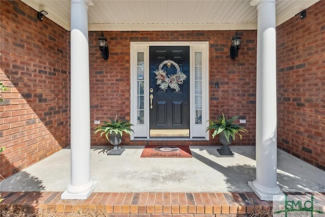 property entrance featuring a porch and brick siding