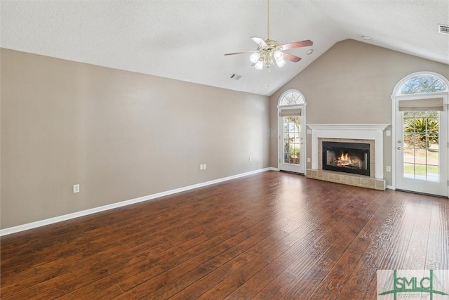 unfurnished living room with a ceiling fan, baseboards, visible vents, a brick fireplace, and wood-type flooring