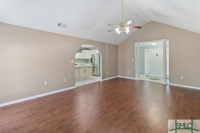 unfurnished living room with arched walkways, wood finished floors, visible vents, a ceiling fan, and vaulted ceiling