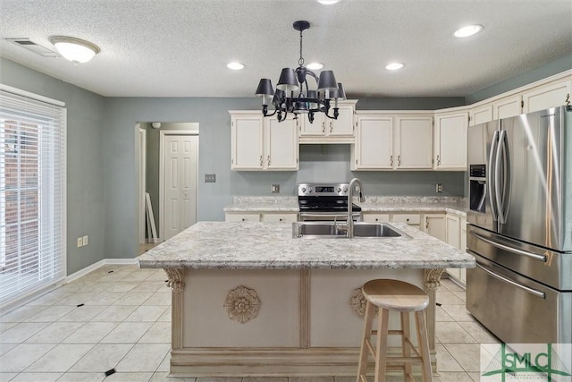 kitchen featuring stainless steel appliances, light tile patterned flooring, a sink, and visible vents