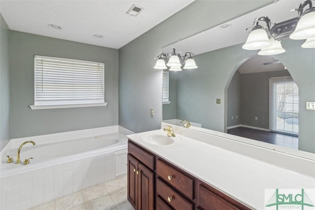 full bathroom featuring visible vents, vanity, a bath, and tile patterned floors