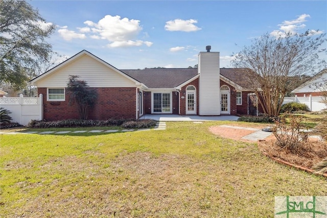 single story home with brick siding, fence, a chimney, and a front lawn