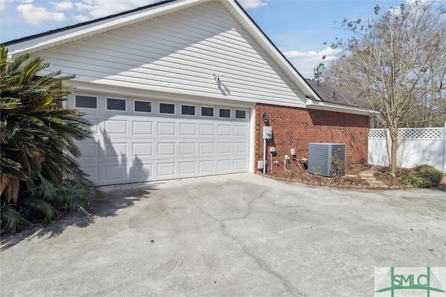 view of side of home with central air condition unit, driveway, fence, and brick siding