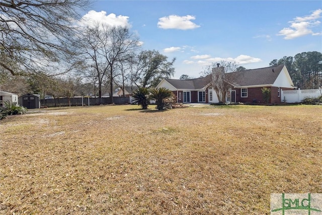 view of yard featuring an outbuilding, fence, and a storage unit