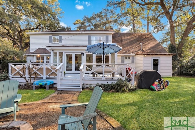 rear view of property with french doors, a yard, and a deck