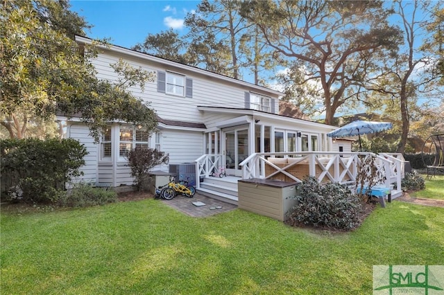 back of house with a wooden deck and a yard