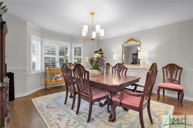 dining space with crown molding, a notable chandelier, baseboards, and wood finished floors