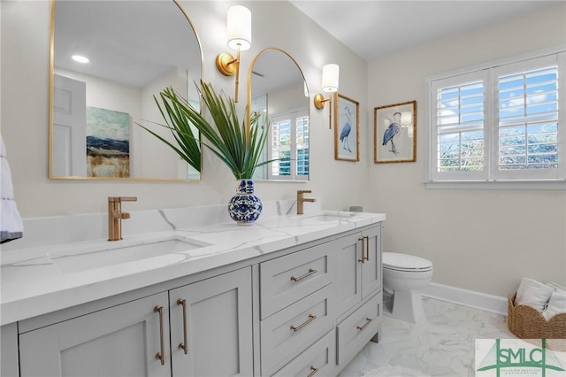 bathroom with double vanity, marble finish floor, and a sink