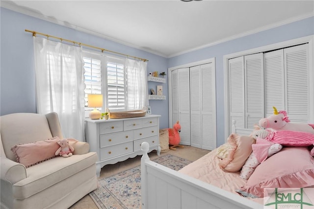 bedroom featuring crown molding and multiple closets