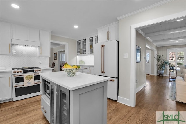 kitchen featuring ornamental molding, white appliances, glass insert cabinets, and wood finished floors