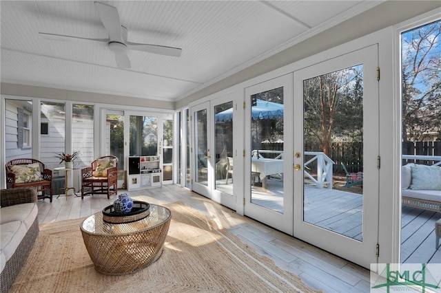 sunroom featuring ceiling fan and french doors