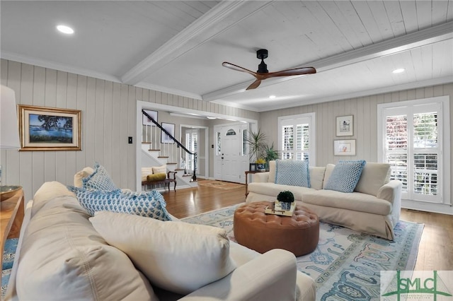 living room featuring recessed lighting, wood finished floors, stairs, ornamental molding, and beamed ceiling