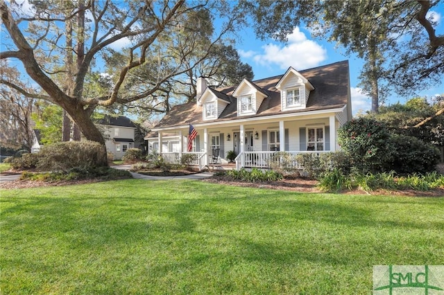 cape cod home with covered porch, a chimney, and a front lawn