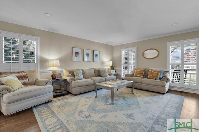 living room featuring ornamental molding, wood finished floors, and visible vents