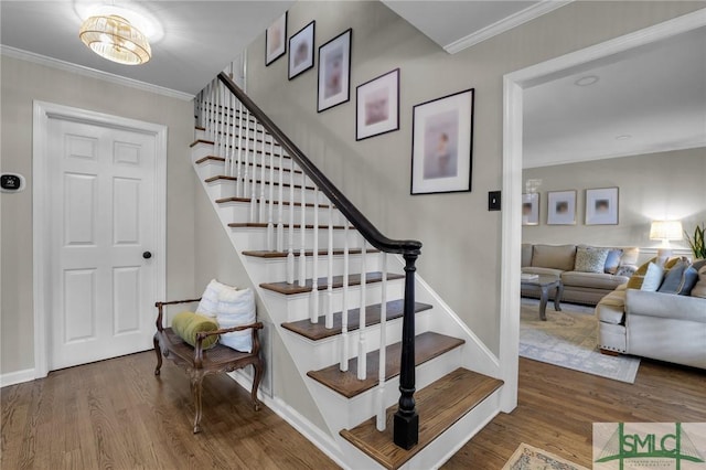 stairway featuring ornamental molding and wood finished floors