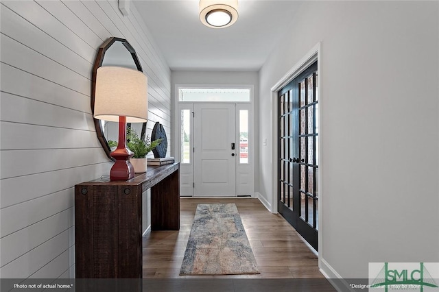 foyer entrance with wood finished floors and baseboards