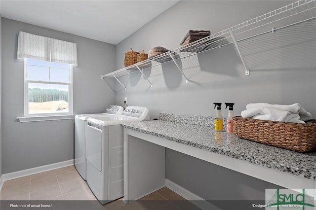 laundry area with washer and dryer, laundry area, light tile patterned flooring, and baseboards