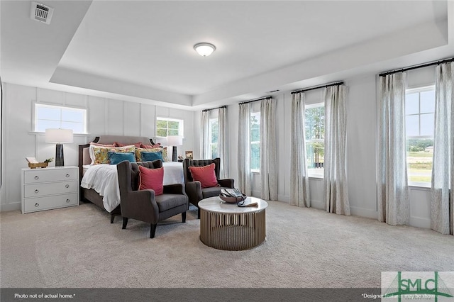 bedroom with a tray ceiling, baseboards, visible vents, and carpet flooring