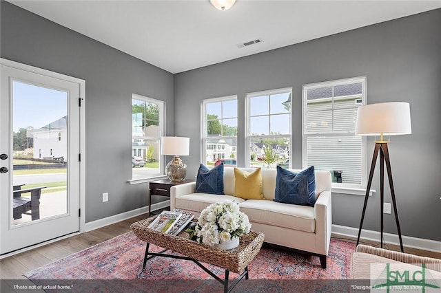 living area with visible vents, baseboards, and wood finished floors