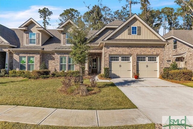 craftsman-style home featuring driveway, a garage, brick siding, board and batten siding, and a front yard