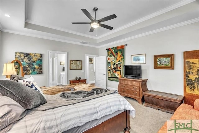 bedroom featuring carpet, crown molding, a raised ceiling, ensuite bathroom, and a ceiling fan