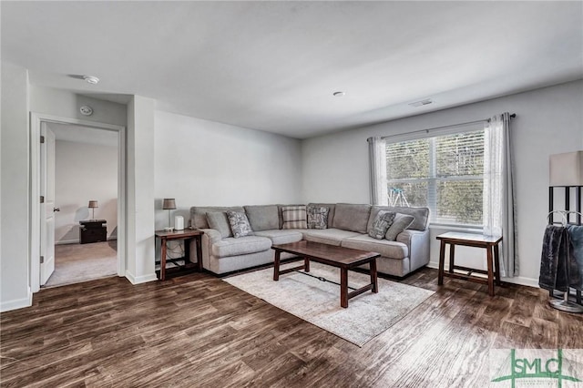 living area featuring visible vents, dark wood finished floors, and baseboards