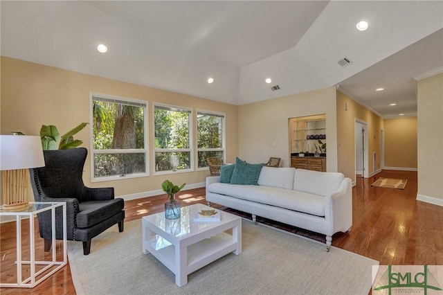 living area featuring recessed lighting, visible vents, vaulted ceiling, and wood finished floors