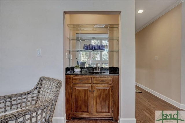 bar with crown molding, recessed lighting, a sink, wood finished floors, and baseboards