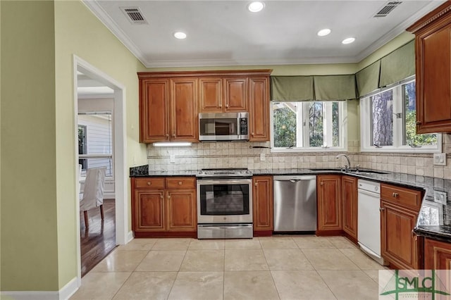 kitchen with stainless steel appliances, tasteful backsplash, a sink, and visible vents