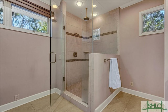 bathroom with a stall shower, tile patterned flooring, and baseboards