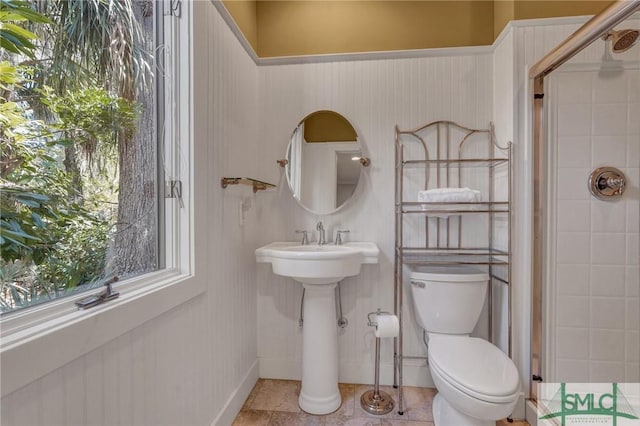 full bathroom featuring toilet, a shower stall, and tile patterned floors