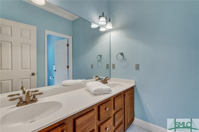 full bath with baseboards, double vanity, a sink, and tile patterned floors