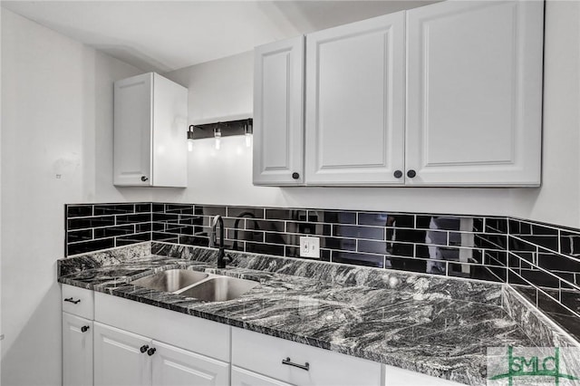 kitchen featuring a sink and white cabinetry