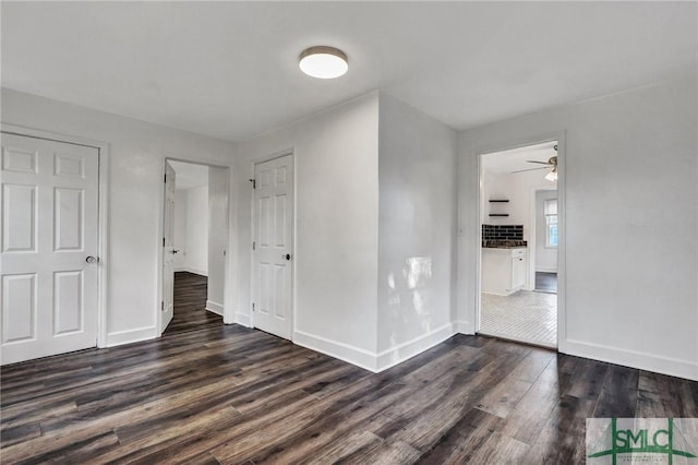 unfurnished bedroom with dark wood-type flooring and baseboards