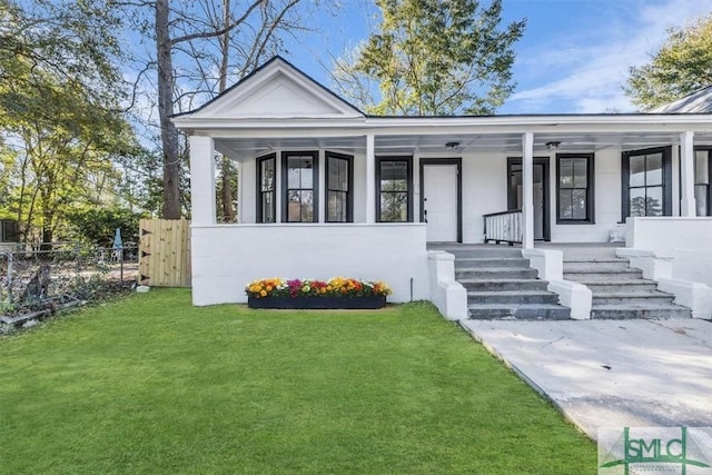 view of front of property featuring a front yard, covered porch, and fence